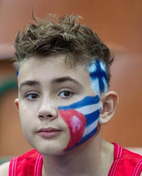 Un giovanissimo tifoso, ma di quale squadra? Le bandiere cubane e finlandesi dipinte sul volto durante Germania-Cuba (Pool B). Epa